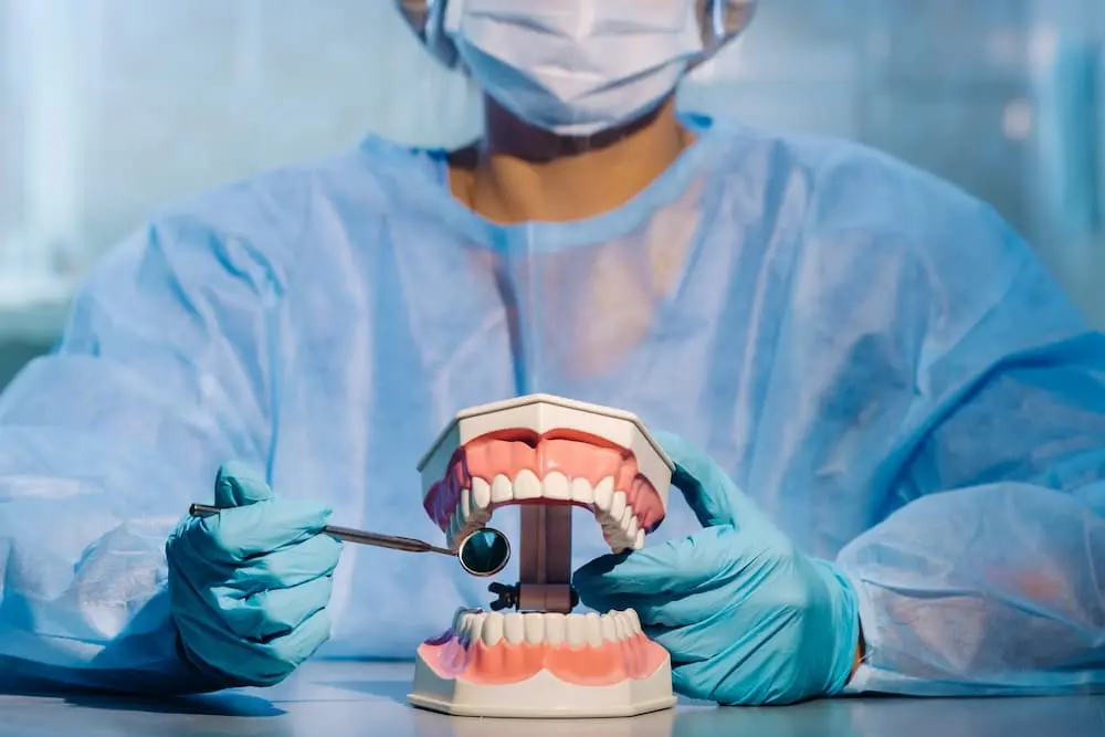 最新消息 2 a dental doctor wearing blue gloves and a mask hol 2022 03 11 10 51 28 utc 1